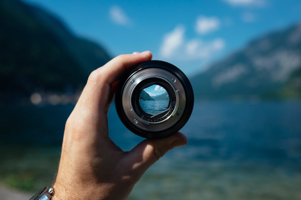 man holding a focused camera lens